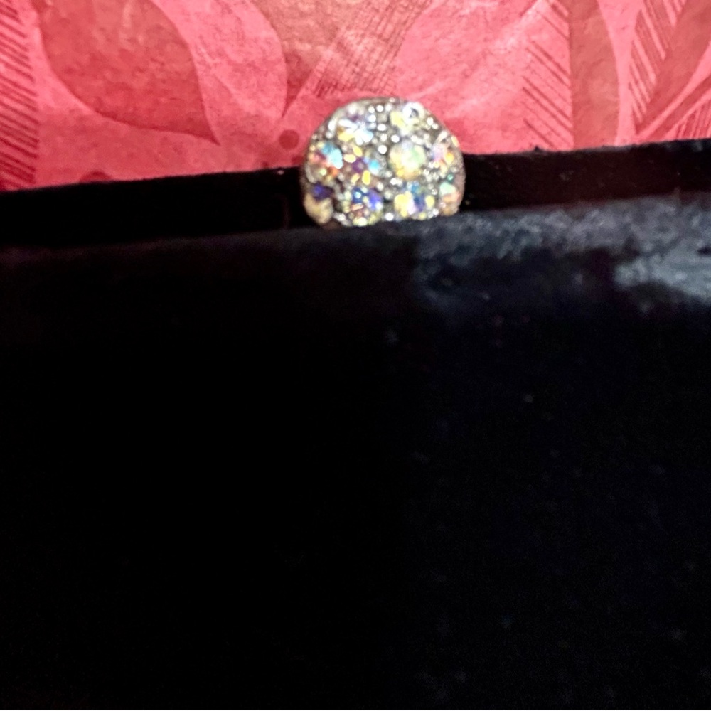 Elegant black velvet material with multi colored rhinestone snap closure.